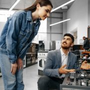 male-salesman-hypermarket-describes-features-gas-stove-female-client