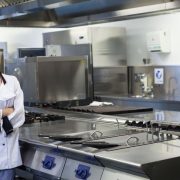 young-smiling-chef-standing-work-surface